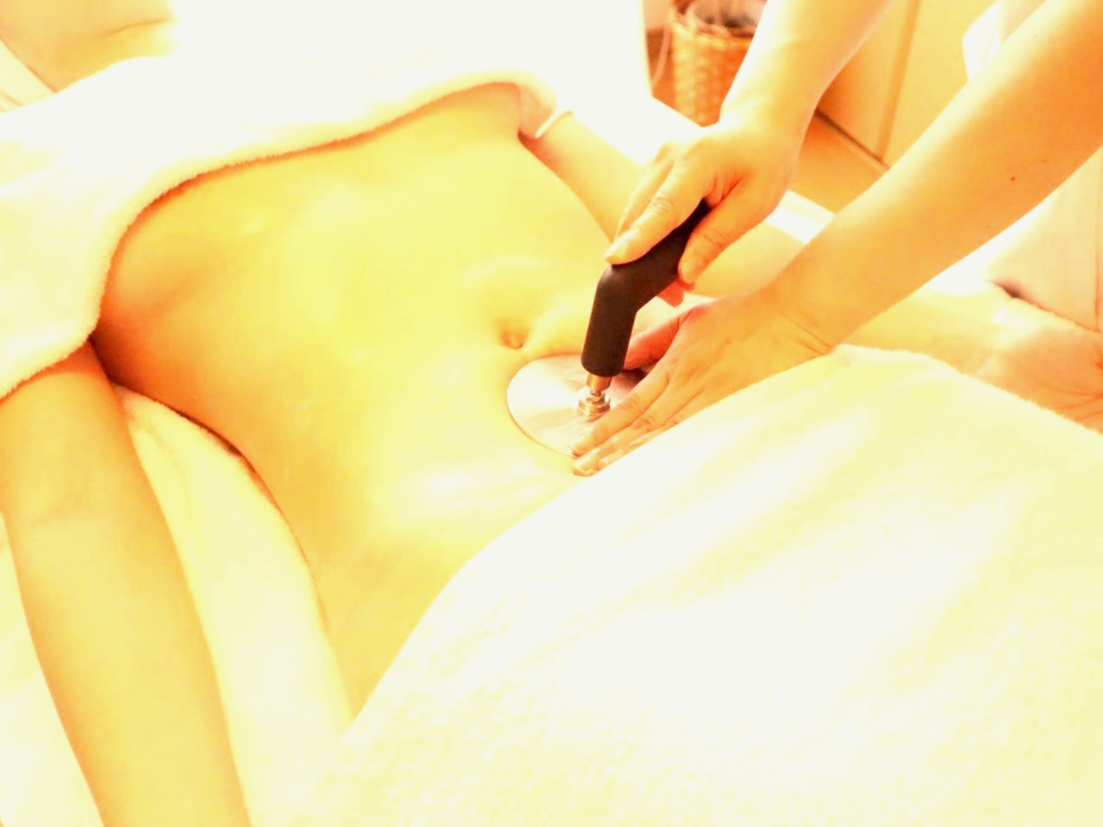 腹部を温熱機器でやさしくケアする様子